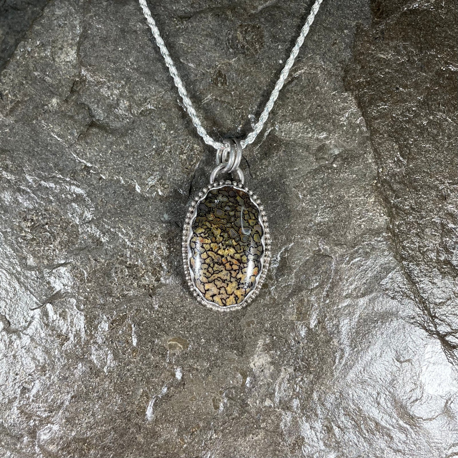 Dinosaur gem bone pendant